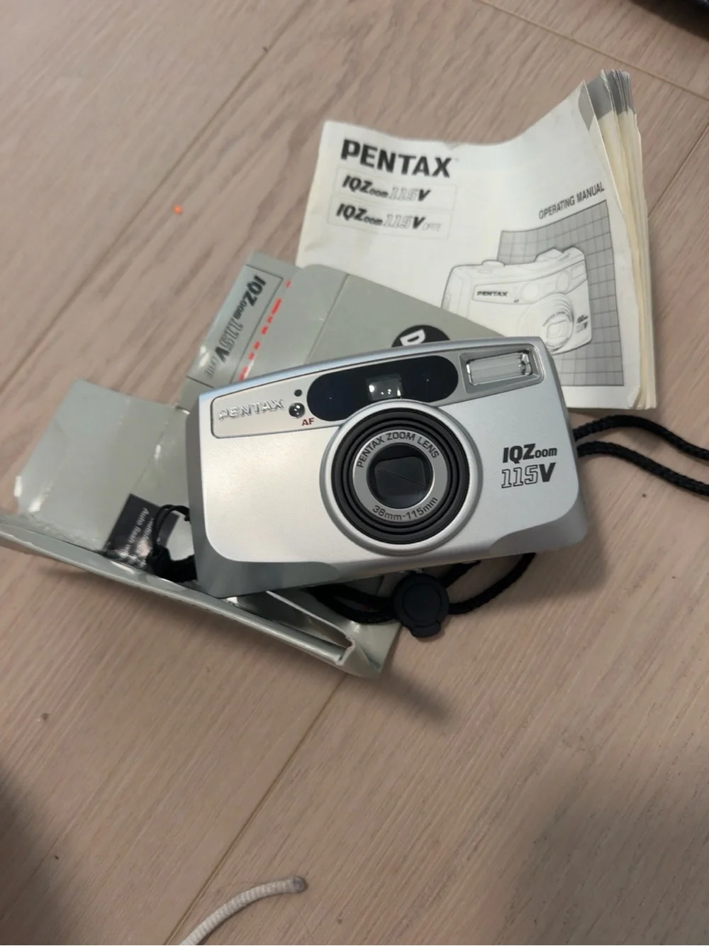 Pentax silver compact film camera with wrist strap